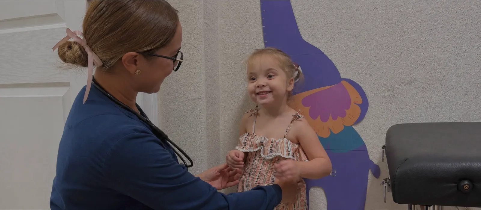 A nurse measuring a smiling young girl at Ellie's World PPEC, a pediatric medical daycare in Port Charlotte, Florida