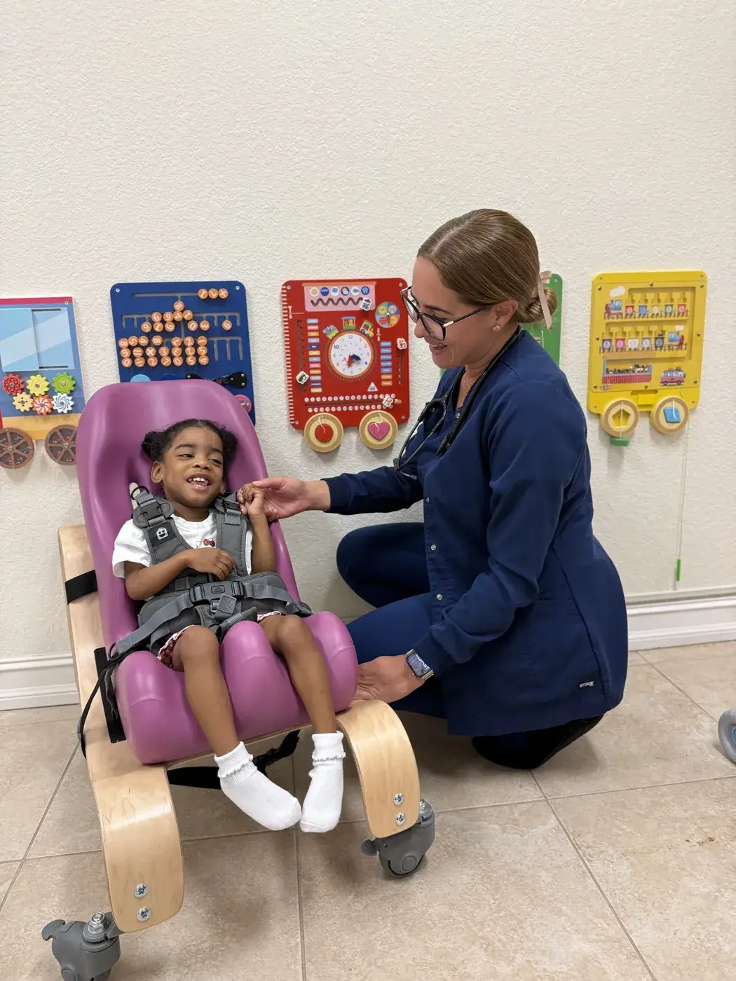 A nurse settling a child into an adaptive positioning chair at Ellie's World PPEC in Port Charlotte, Florida