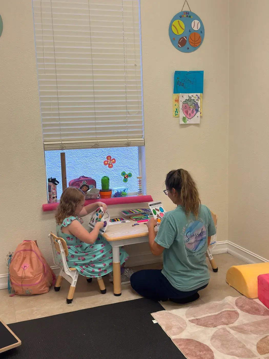 A therapist working one-on-one with a child at a small table at Ellie's World PPEC in Port Charlotte, Florida